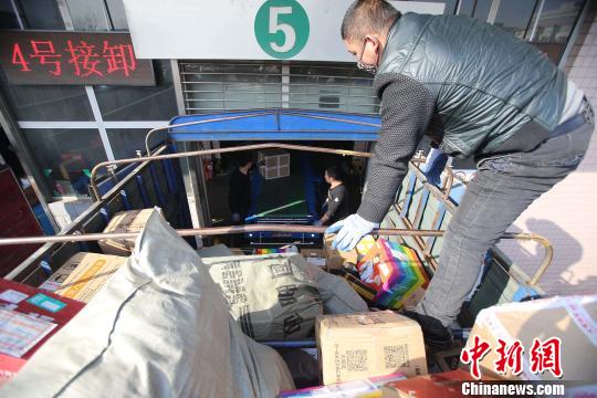 資料圖：工作人員正在給快遞包裹裝車。張?jiān)啤z